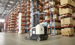 A photograph of a warehouse with a forklift truck