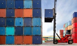 A photograph of shipping containers being stacked up