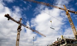 A photograph of 2 cranes on a construction site