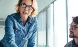 A photograph of a lady with short blonde hair wearing glasses