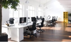 A photograph of an office with computers, desks and chairs